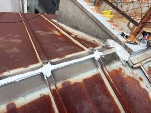 屋根の取り合い部分にシーリング補修を行う雨漏り修理の作業風景