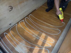 尼崎市 床リフォーム コンパネ施工前の接着剤（ボンド）塗布作業の様子