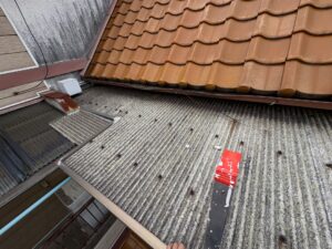 ヒビや色あせが見られる古い波板屋根
