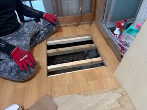 尼崎市の洗面所リフォームで床を開口して下地の状態を確認している様子