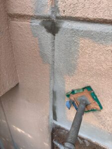 西宮市の外壁塗装工事で下地処理を行う様子