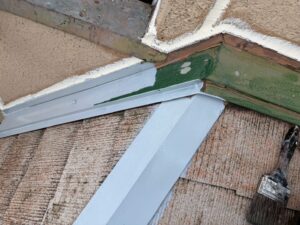 西宮市の棟板金に錆止め塗装を施工する様子