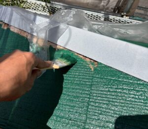 西宮市のスレート屋根に下塗り塗装を行う様子