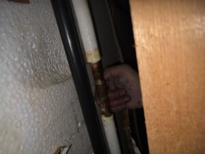 尼崎市で浴室漏水修理のため給湯管を点検している様子