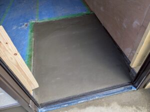 尼崎市で駐車場を部屋へリフォームするため玄関まわりと基礎にモルタル補修を施工している様子