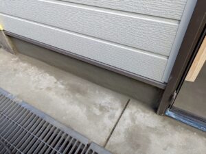 尼崎市で駐車場を部屋へリフォームするため玄関まわりと基礎にモルタル補修を施工している様子
