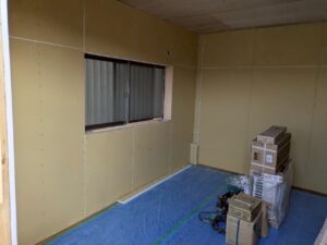 駐車場を部屋へリフォームするため壁と天井に石膏ボードを施工している様子