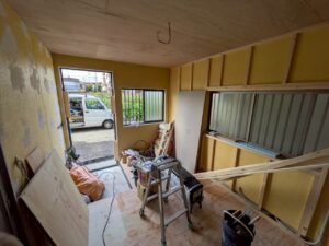 尼崎市で駐車場を部屋へリフォームするため壁下地工事を行っている様子