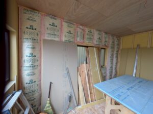 尼崎市で駐車場を部屋へリフォームするため壁に断熱材を施工している様子