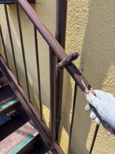 尼崎市の外階段塗装で手すり部分を塗装している様子