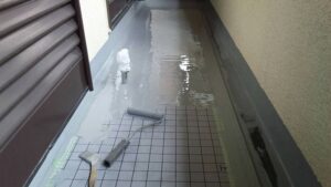 尼崎市のベランダに1回目のウレタン防水を施工している様子