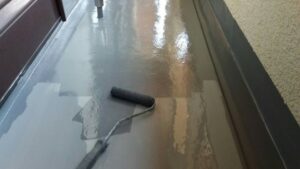 尼崎市のベランダに2回目のウレタン防水を施工している様子