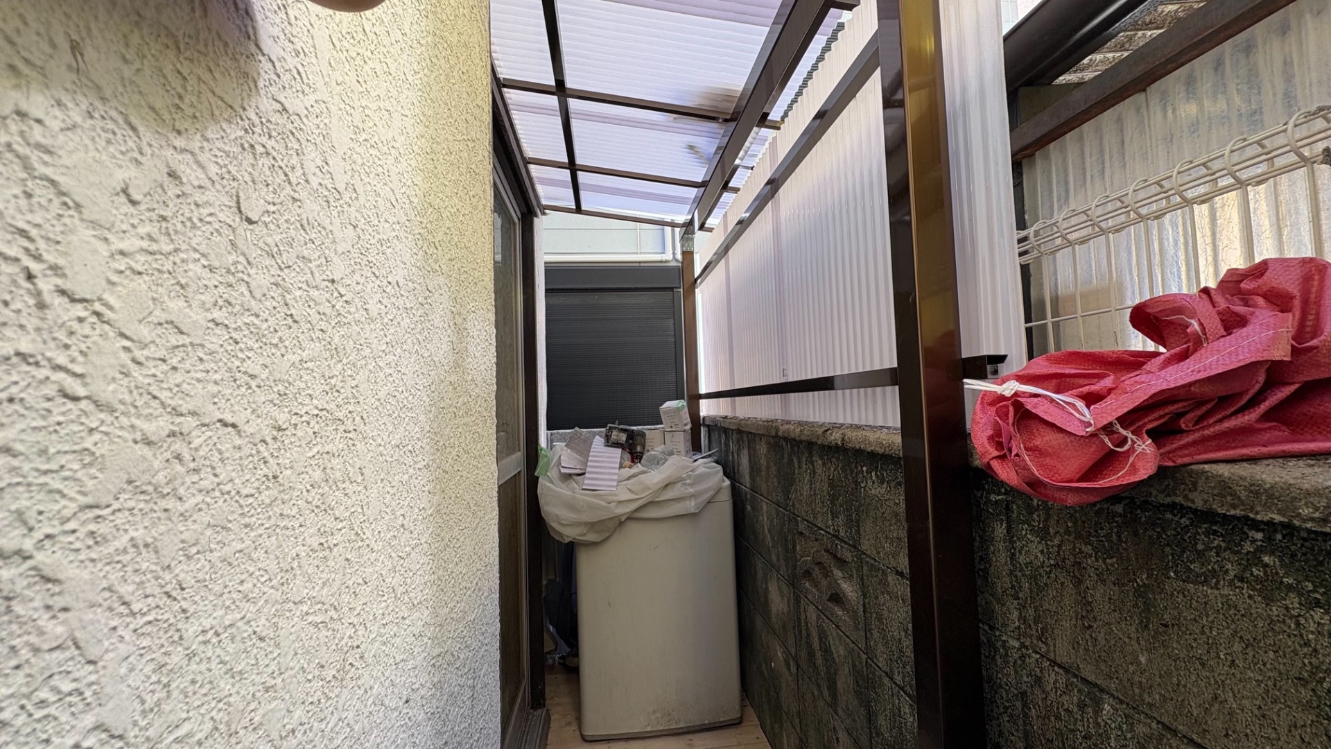 住宅の1階裏庭にある細長いスペースと既存のテラス屋根の様子